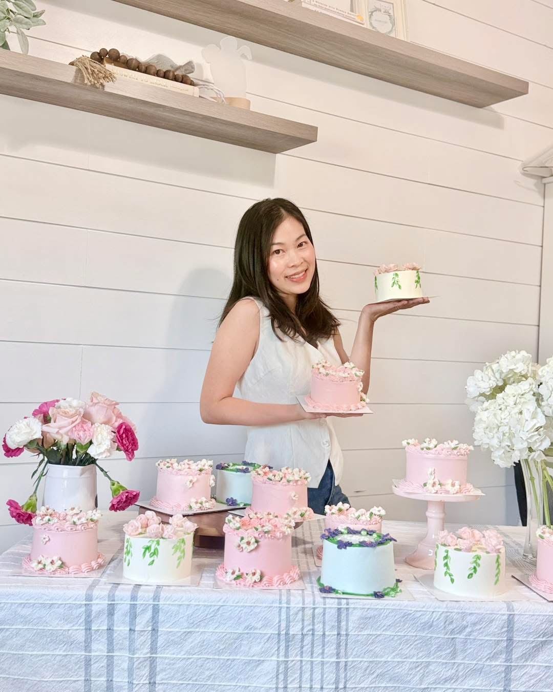 The baker behind Kitasweets holding one of her floral mini cakes