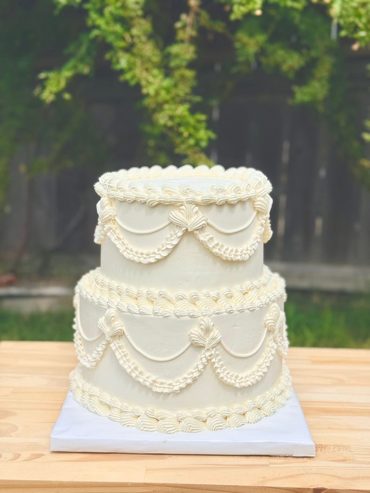 Two tier ivory cake with vintage swag piping
